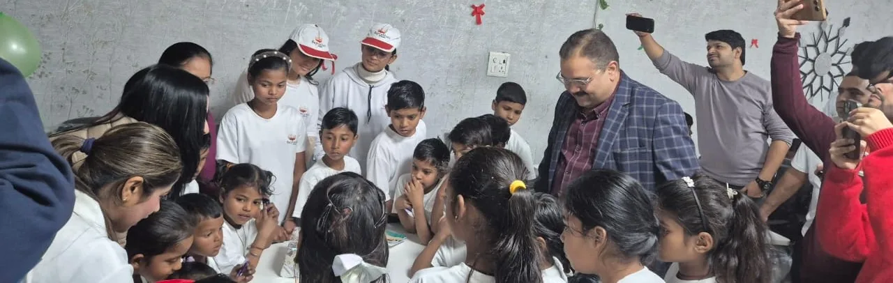 Vikas Prabhakar and the VMS team celebrating Christmas with children in white T-shirts