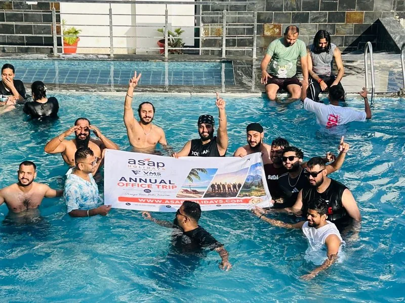 The VMS and ASAP Holidays team celebrating in a pool on the annual office trip